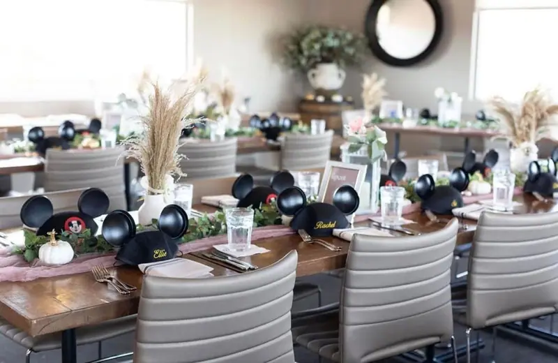Reception tables set with Mickey Mouse ears at each place, pampas grass and greenery