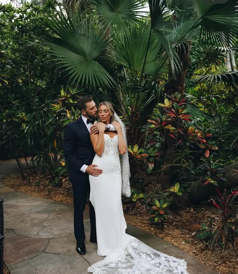Lisa & Joel holding each other in a garden of tropical plants